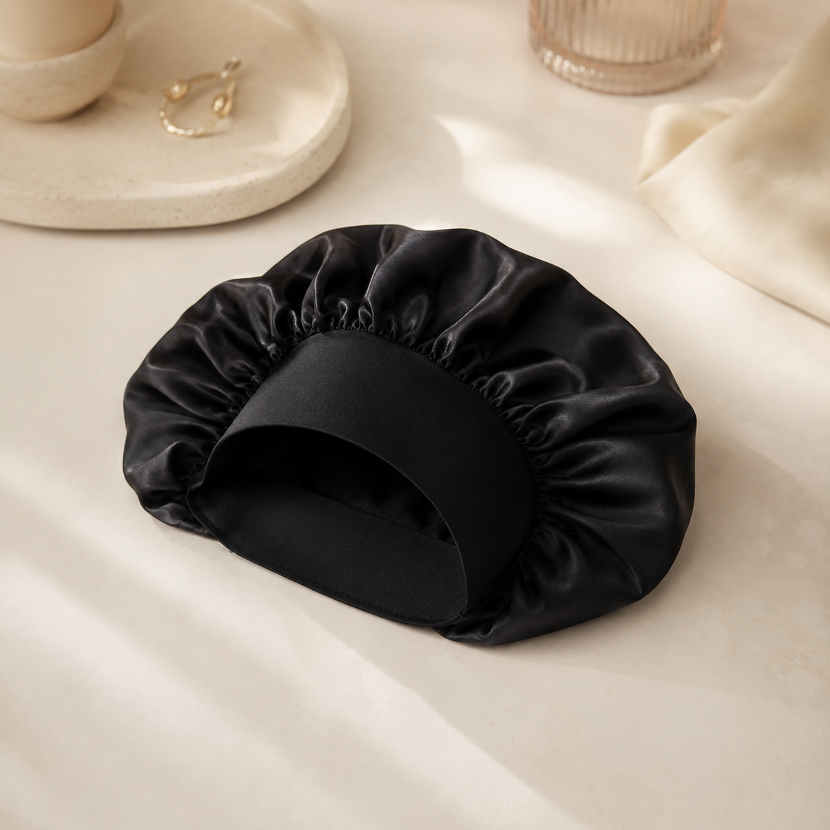 Bonnet de nuit en satin noir NUIT STUDIO sur fond crème premium